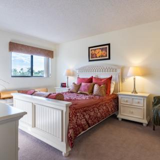 A cozy bedroom with a decorative bedspread, elegant furniture, and warm lighting.