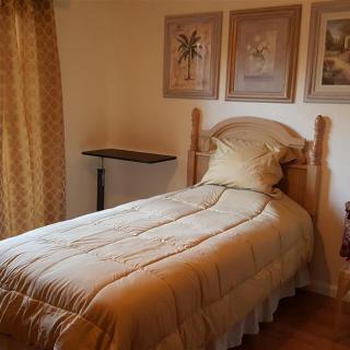 A cozy bedroom with a single bed, adorned with framed artwork on the wall.