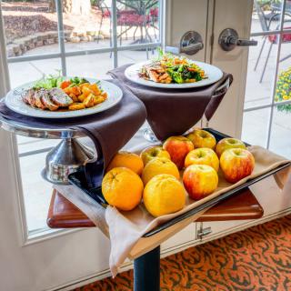 A table with plates of food and a display of fresh apples.