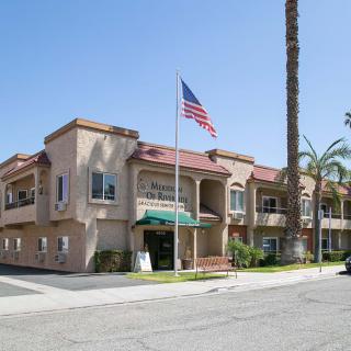 A hospital building with an American flag and palm trees on a sunny day.
