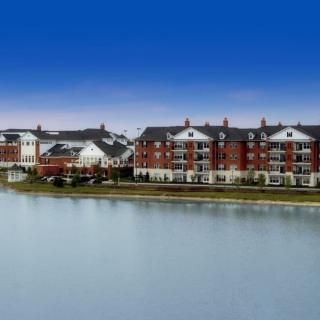 A row of waterfront apartment buildings under a clear blue sky.