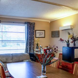 A cozy living and dining area featuring a table, sofa, and decorative elements.