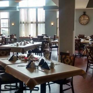 An empty restaurant dining area with neatly arranged tables and chairs.