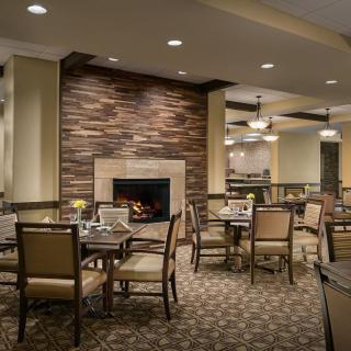 A cozy restaurant dining area with a fireplace and neatly arranged tables and chairs.