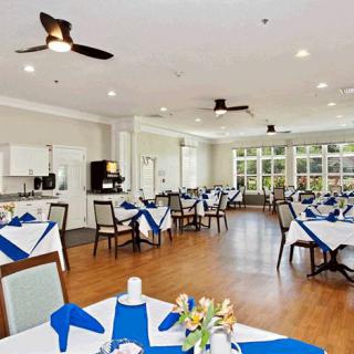 A bright and spacious dining room with neatly arranged tables and blue-white decorations.