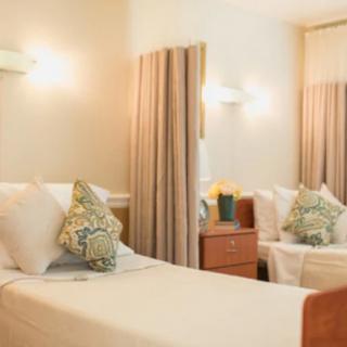 A cozy bedroom with soft lighting, decorative pillows, and elegant curtains.