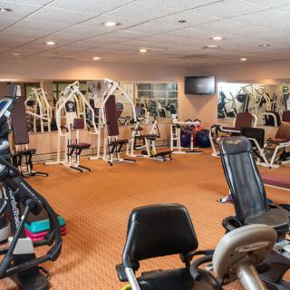 A well-equipped gym with various exercise machines and fitness equipment.