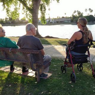 A group of people enjoying a serene moment by the lake during sunset.