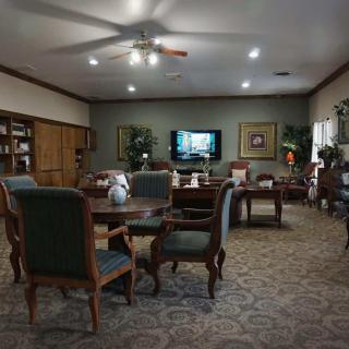 A cozy living room with comfortable seating, a television, and bookshelves.