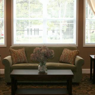 A cozy living room with a sofa and a coffee table in front of large windows.