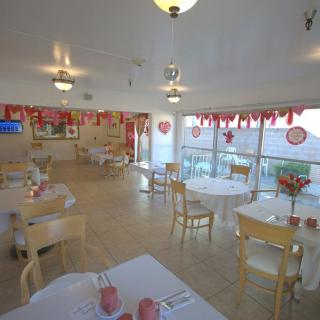 Cozy indoor dining area decorated with a Valentine's Day theme, featuring tables and chairs arranged neatly with festive decor.