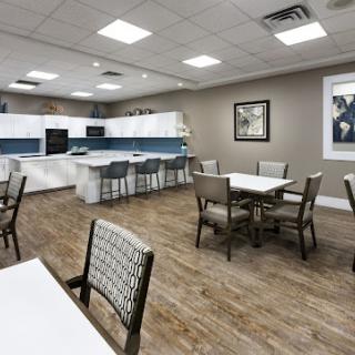 A modern dining area featuring white cabinetry and blue accents, designed for comfort and style.