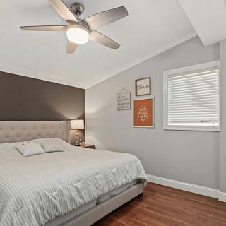 A cozy and modern bedroom featuring a comfortable bed, stylish decor, and a ceiling fan for added comfort.