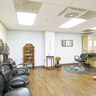 A well-lit salon interior with a waiting area and hair styling stations.