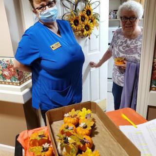 Residents engage in a festive autumn activity, creating decorative crafts together.