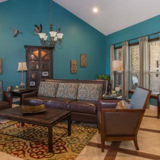A cozy living room with teal walls featuring a comfortable seating arrangement, a wooden coffee table, and decorative elements.