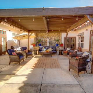 A spacious and inviting patio with comfortable seating under a pergola, perfect for outdoor gatherings.