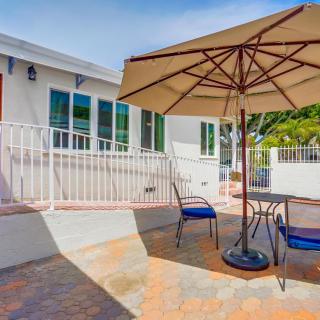 A sunny patio with an umbrella-shaded table and chairs.