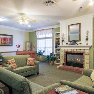 A cozy living room with a fireplace and green couches.