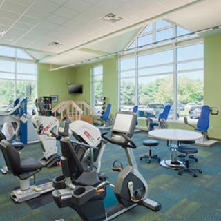 A view of a bright and spacious fitness center equipped with various exercise machines.