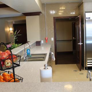 A modern kitchen featuring a sleek countertop, a fruit basket, and stainless steel appliances.