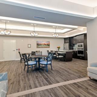 Modern interior featuring an open kitchen and dining area with elegant chandeliers and hardwood flooring.