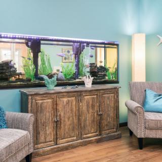 A cozy living room featuring a large aquarium and comfortable seating.