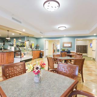 A cozy dining area with neatly arranged tables and chairs, featuring soft lighting and tasteful decor.