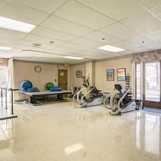 A well-equipped rehabilitation gym featuring exercise machines and therapy mats.