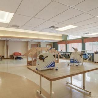 An indoor rehabilitation center with exercise equipment and spacious layout.