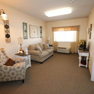 A cozy living room with sofas, an armchair, and elegant decor.