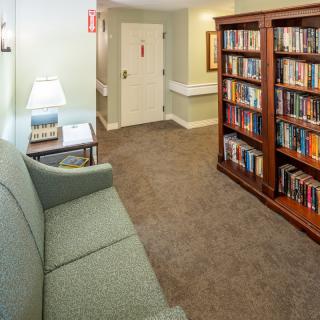 A cozy reading corner with a couch and a bookshelf filled with books.
