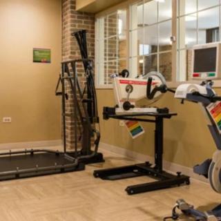 A well-equipped gym room featuring a treadmill and other fitness machines.