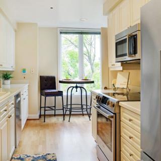 A modern kitchen interior with stainless steel appliances and a cozy dining area by the window.