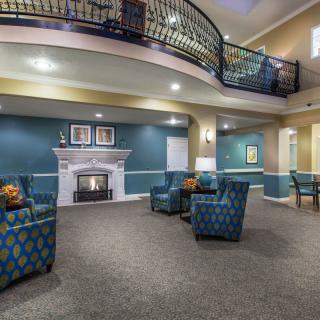 A spacious lobby with cozy armchairs, a fireplace, and an elegant balcony.