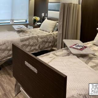 A modern hospital room with two beds and medical equipment.