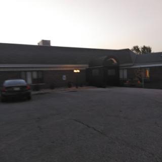 An exterior view of a building during the evening, featuring a parking area.