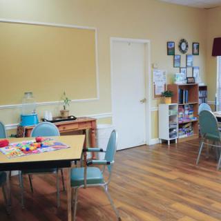 An educational or meeting space featuring tables and chairs with toys on the surface.