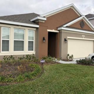 A suburban residential house with a neat lawn and driveway.