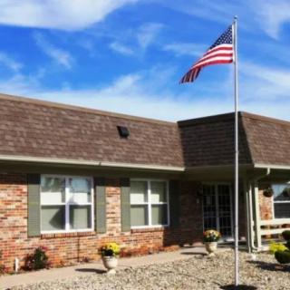 A brick house with an American flag on a clear day.