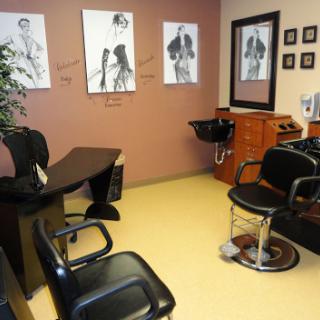 A stylish and welcoming hair salon featuring barber chairs and artistic wall decor.