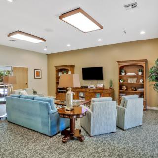 A cozy living room with a seating area, television, and bookshelves.