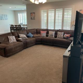 A spacious living room featuring a large sectional sofa and a television, perfect for relaxation and entertainment.