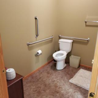 A clean and accessible bathroom with safety handrails.
