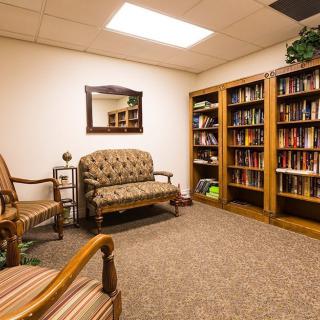 A cozy library corner with bookshelves and comfortable seating.