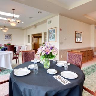 A beautifully set dining table with a floral centerpiece in an elegant restaurant interior.