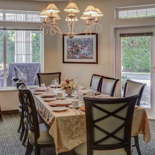 A well-set dining room table with elegant decor and ample natural light.