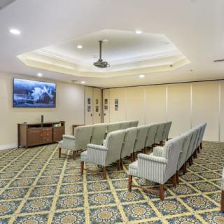 An interior view of a conference room with rows of seating and a projector screen.