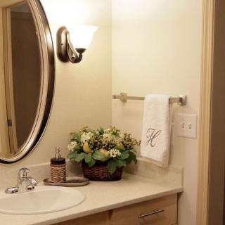 A cozy bathroom with a circular mirror and elegant decor.
