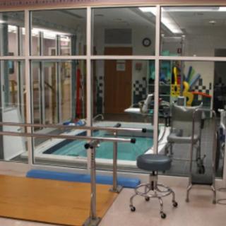 A rehabilitation room featuring a therapy pool and exercise equipment.